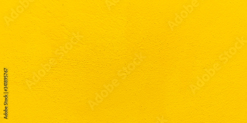 Blurred Yellow stucco wall background. Yellow painted cement wall texture.
