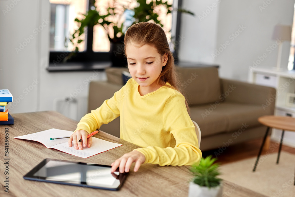children, education and school concept - happy student girl with tablet pc computer writing to notebook at home children, education and school concept - happy student girl with tablet pc computer writing to notebook at home