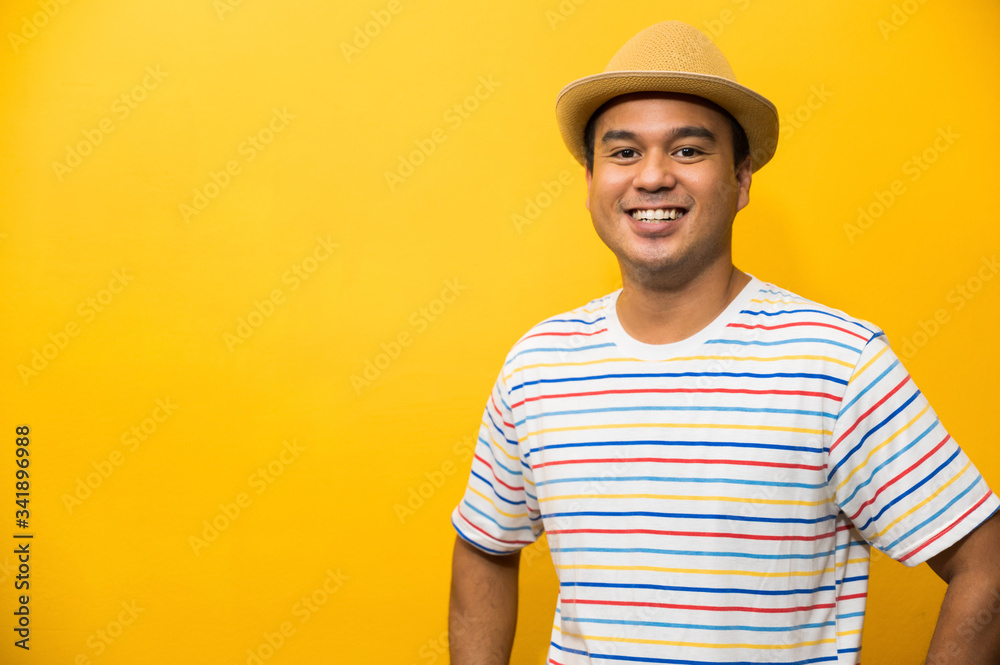 Young handsome asian man on yellow background.