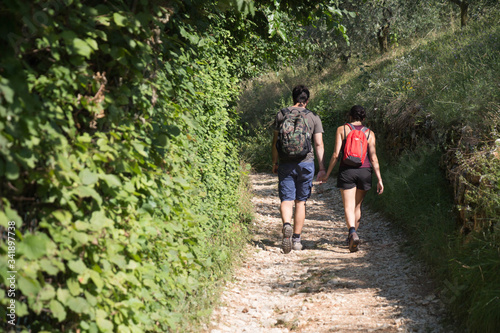 Young couple walking on a forest path in summer.