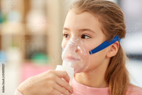 health, medical equipment and people concept - sick little girl wearing oxygen mask