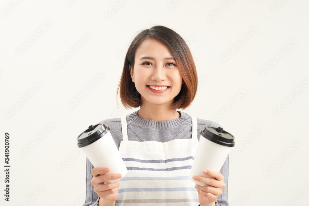 Portrait of kind friendly pleasant girl giving two big latte isolated on gray background copy-space Portrait of kind friendly pleasant girl giving two big latte isolated on gray background copy-space
