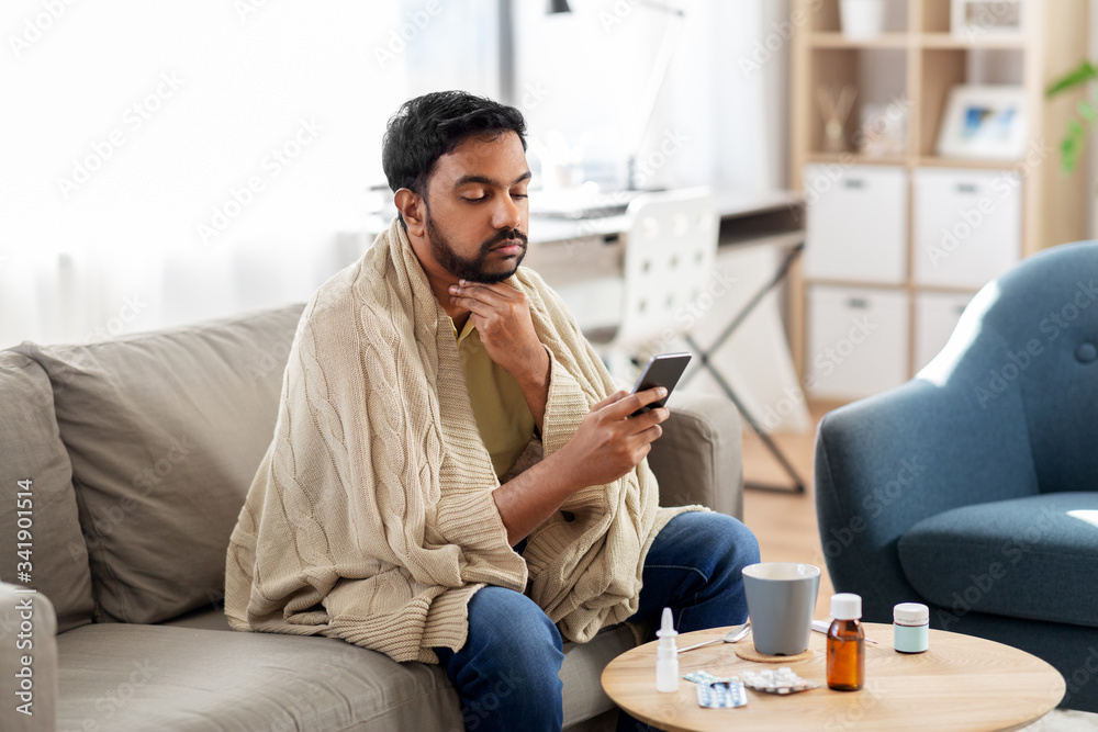 © Syda Productions - health, cold and people concept - sick young indian man in blanket with smartphone at home © Syda Productions - health, cold and people concept - sick young indian man in blanket with smartphone at home