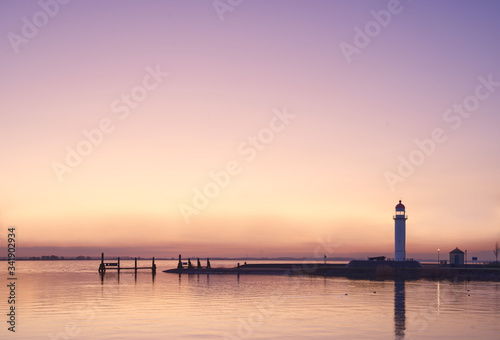 Panorama of harbor lighthouse landscape, pink sky at sunset, copy space © Wheat field