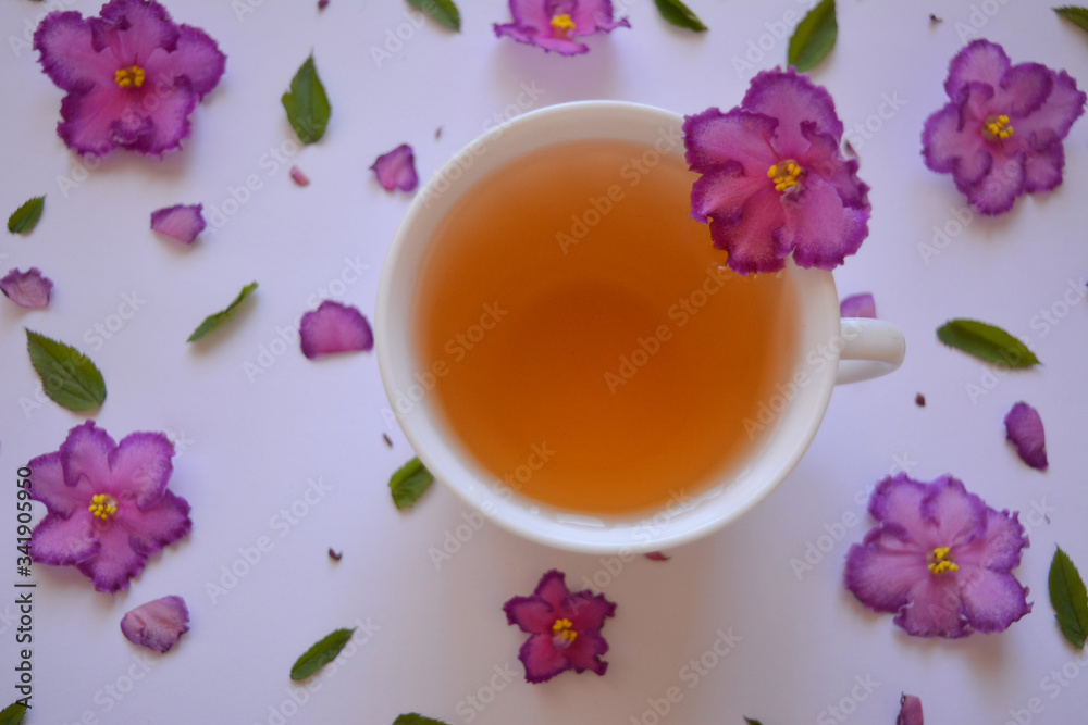 Gourmet concept. Elegant spring (summer) drink.Сup of tea with flowers .Аromatic hot drink. Healthy lifestyle. herbal tea.Top view Gourmet concept. Elegant spring (summer) drink.Сup of tea with flowers .Аromatic hot drink. Healthy lifestyle. herbal tea.Top view