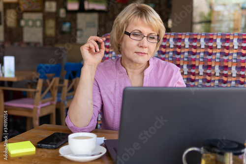 A woman is working with a laptop at a table in the room