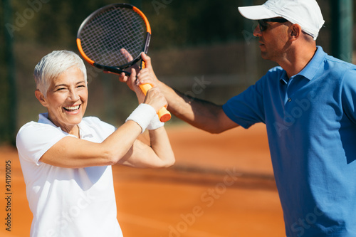 Active Senior Woman Practicing Tennis © Microgen
