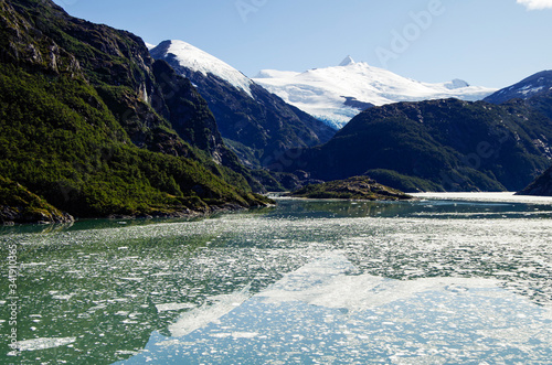 Breathtaking panoramic view of mountains and glaciers along Beagle Channel in Glacier Alley landscape scenery while cruising on cruiseship or cruise ship liner in Patagonia on sunny day and ice floes photo