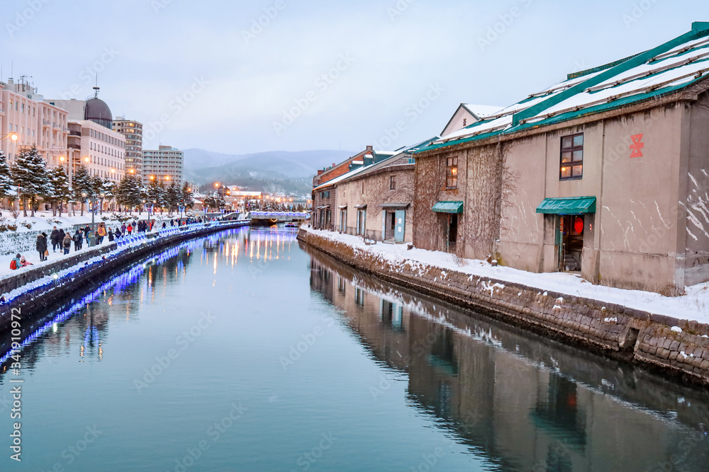 Otaru Canal in Winter with twilight light. One of Beautiful scene in Otaru canal with old warehouses. It is a popular tourist attraction of Hokkaido, Japan.