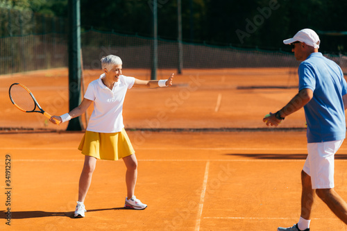 Older Woman Practicing Tennis with Instructor