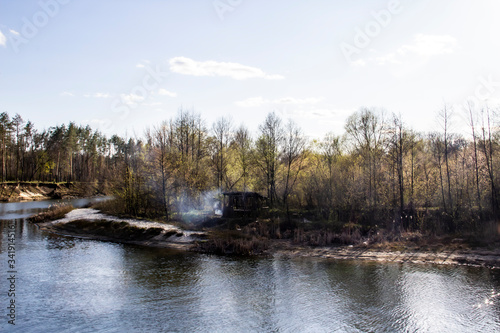 Ukranian landscape in the forest. Pine forest with a river name Psel in city Sumy. Pine trees on a river bank in Ukraine. Beautiful river called Psel. Old, ruined gazebo near the river with a bonfire