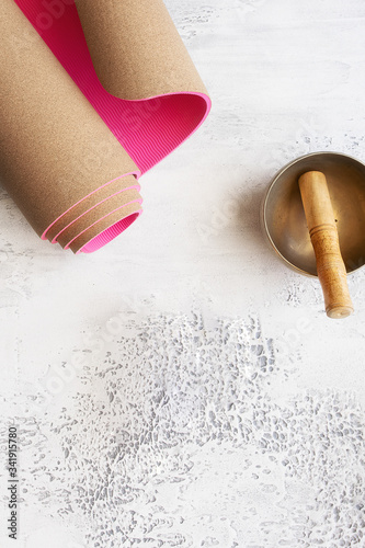 Eco cork yoga mat and Tibetan music bowl on white background for home pratice concept.  Yogi Essentials for practice and meditation. photo