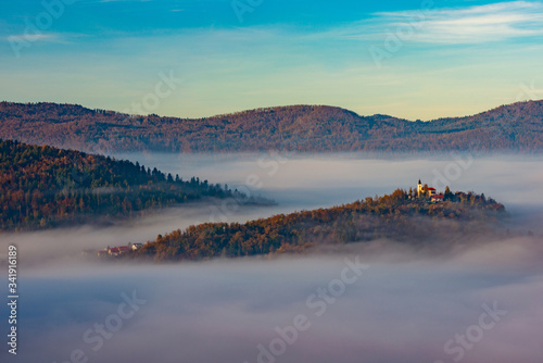 the church on the hill and fir trees on an autumn day