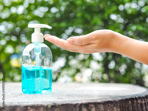 Woman's hands is pressing a bottle of Alcohol Gel to clean her hands. Alcohol gel is very important in daily life.