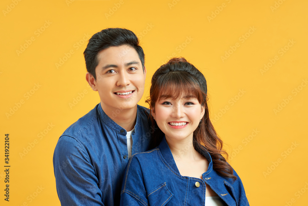 Excited cheerful young couple standing isolated over yellow background Excited cheerful young couple standing isolated over yellow background