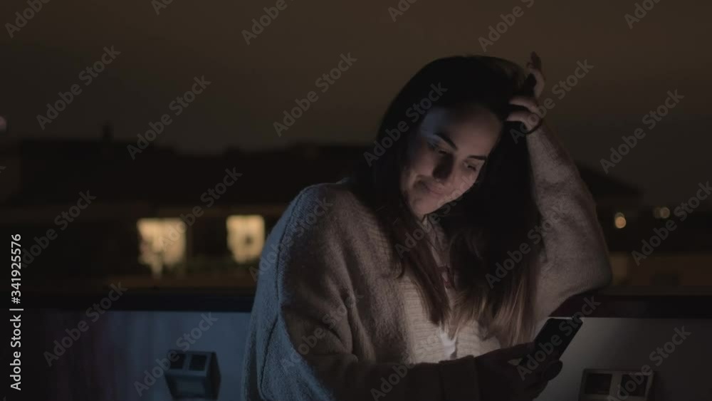 young girl having a video call with her family on a rooftop at night young girl having a video call with her family on a rooftop at night