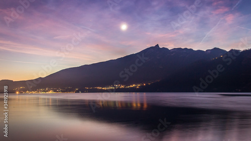 sunset over the mountains with reflection on a lake and pink colors
