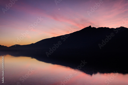 sunset over the mountains with reflection on a lake and pink colors