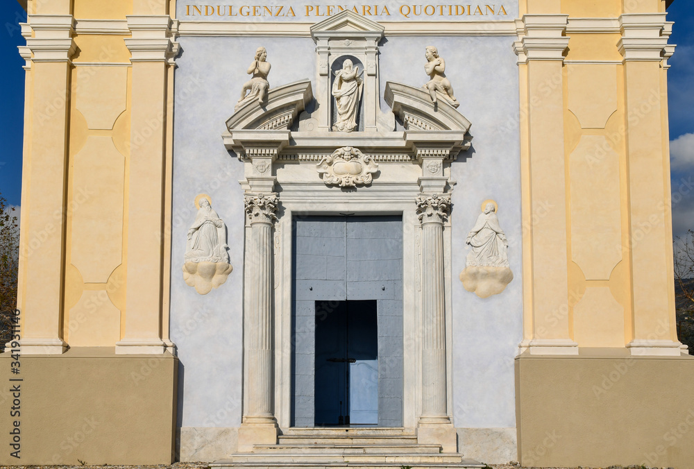 Close-up of the entrance portal of the Lady of the Coast (Madonna della Costa) Sanctuary, with a votive shrine of the Virgin Mary and bas-reliefs of Saints, Sanremo, Imperia, Liguria, Italy