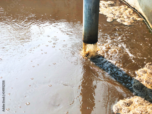 Cuadro en lienzo Metal pipeline of Sludge treatment in wastewater management system, Water treatment tube flowing brown smelly liquid and drying, made for fertilization can use in agriculture field