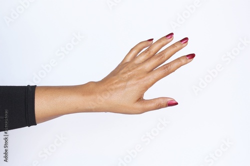 Wet back side of woman hand red nail polish wearing black long sleeve t-shirt. photo isolate on white copy space