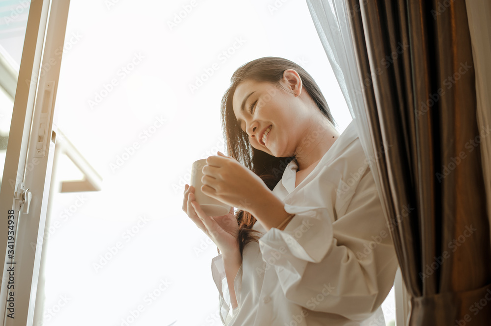Young woman asia living at home relaxing and drinking cup of hot coffee in the bedroom on holiday. Asian, asia, relax, alone, technology, lifestyle concept. Young woman asia living at home relaxing and drinking cup of hot coffee in the bedroom on holiday. Asian, asia, relax, alone, technology, lifestyle concept.