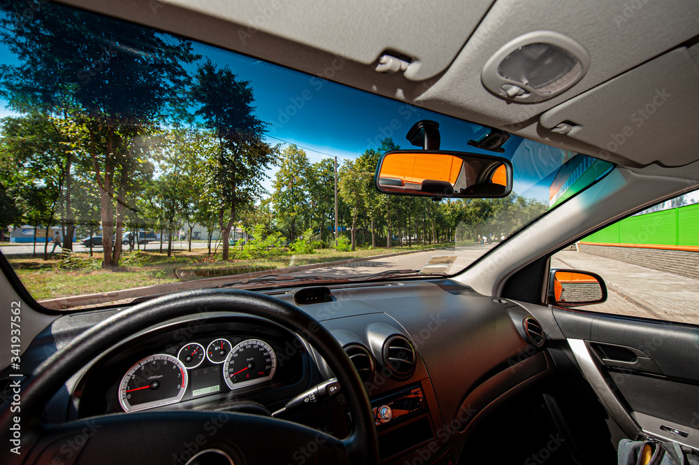 view from the car of the city landscape, rear-view steering wheel mirrors and dashboard.