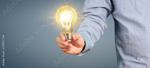 Hand of holding illuminated light bulb. innovation inspiration concept.