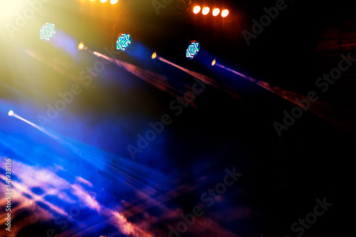 light illumination and spotlights on a dark background during a musical performance of a rock band.
