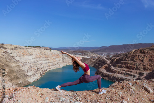 Young woman is practicing yoga at mountain lake