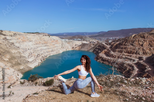 Young beautiful woman is practicing yoga at mountain lake