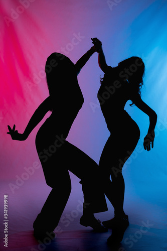 Silhouette about dancing women with colorful backround