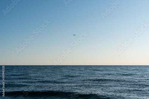 plane flies over the Black Sea in Sochi on a clear sunny day