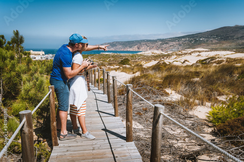 Adult female tourist enjoying costal view of Praia do Guincho Beach. Cascais, Portugal. This is popular blue flag Atlantic beach for surfing, windsurfing, and kitesurfing photo