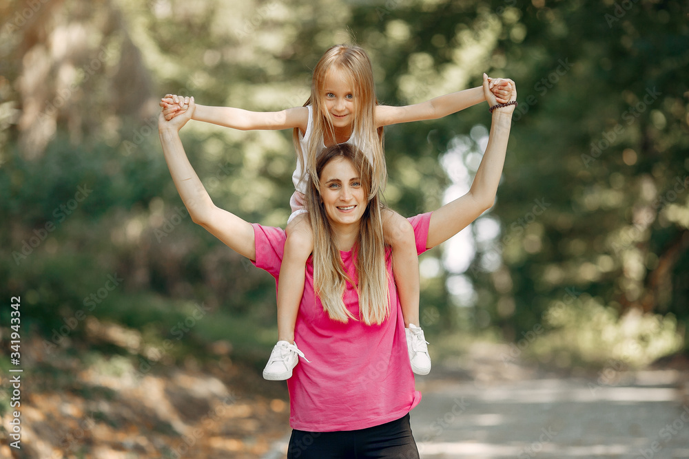 Obraz premium Family in a summer park. Mother in a pink t-shirt. Cute little girl