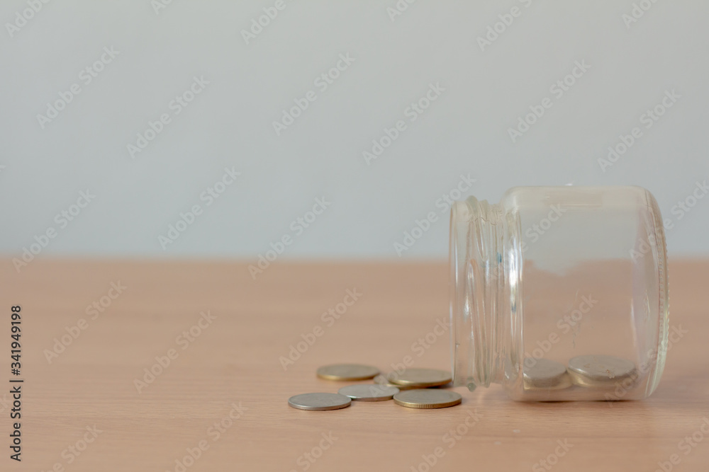 Coins with empty glass jar on wood table. Saving money concept. No money. Coins with empty glass jar on wood table. Saving money concept. No money.