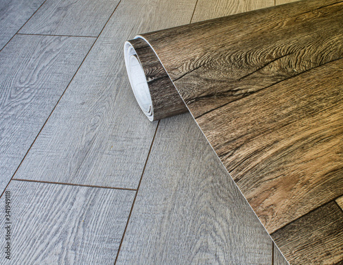 Fotografie Roll of linoleum with a wood texture. Types of floor coverings.