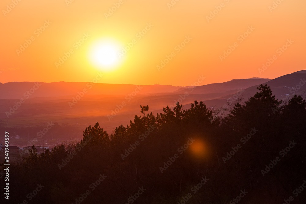 Beautiful summer sunset with trees and hills. 