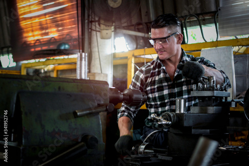 Industrial engineer worker wearing safe glasses, operating with machinery at manufacturing plant factory, working with machine in industry concept