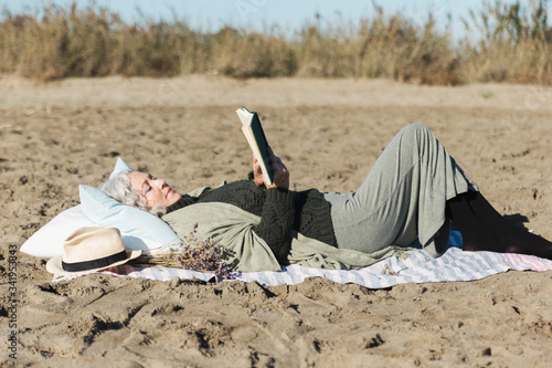Senior woman reading book outdoors