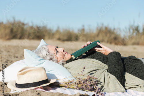 Peaceful senior woman holding book