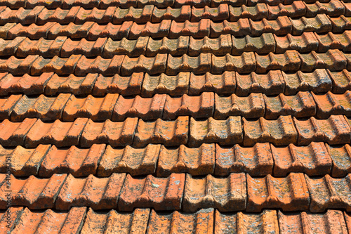 Texture of orange clay roof tiles. Red old dirty roof. Old roof tiles. Construction equipment build a house.