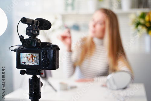 Display of camera recording video blog for blonde beauty blogger woman with make-up at home studio. Influencer vlogger girl live streaming cosmetics masterclass. Online learning and marketing concept. photo