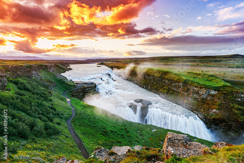 Gullfoss, Iceland, canyon waterfall in a dramatic landscape. Spot of Golden Circle round touristic route in Iceland. Beauty of Icelandic nature scene during amazing sunset.