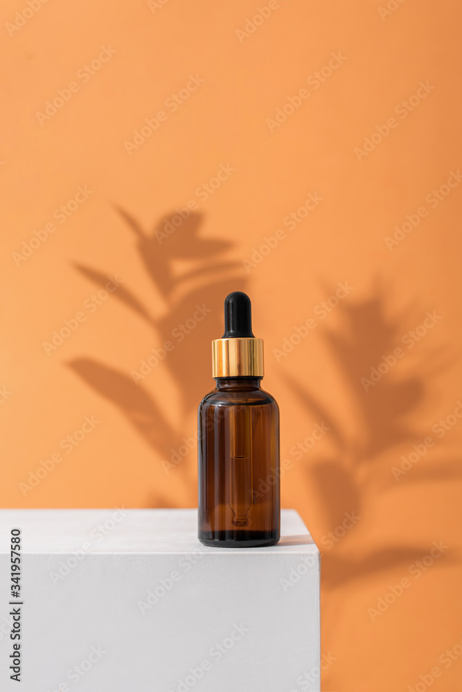 Glass brown bottle of serum with a pipette for skin care. Direct lighting, contrast of light and shadow. The concept of health and beauty. minimalism, save the space Glass brown bottle of serum with a pipette for skin care. Direct lighting, contrast of light and shadow. The concept of health and beauty. minimalism, save the space