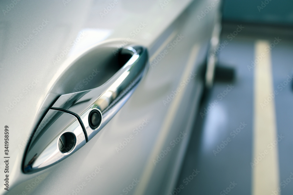 door handle of modern car parked at parking lot of condominium, push button to lock vehicle, keyless entry door handle, selective focus