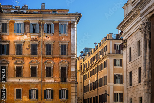 Widok na zabytkowe kamienice w centrum Rzymu, Włochy. Piękne błękitne niebo kontrastuje z kolorowymi fasadami budynków