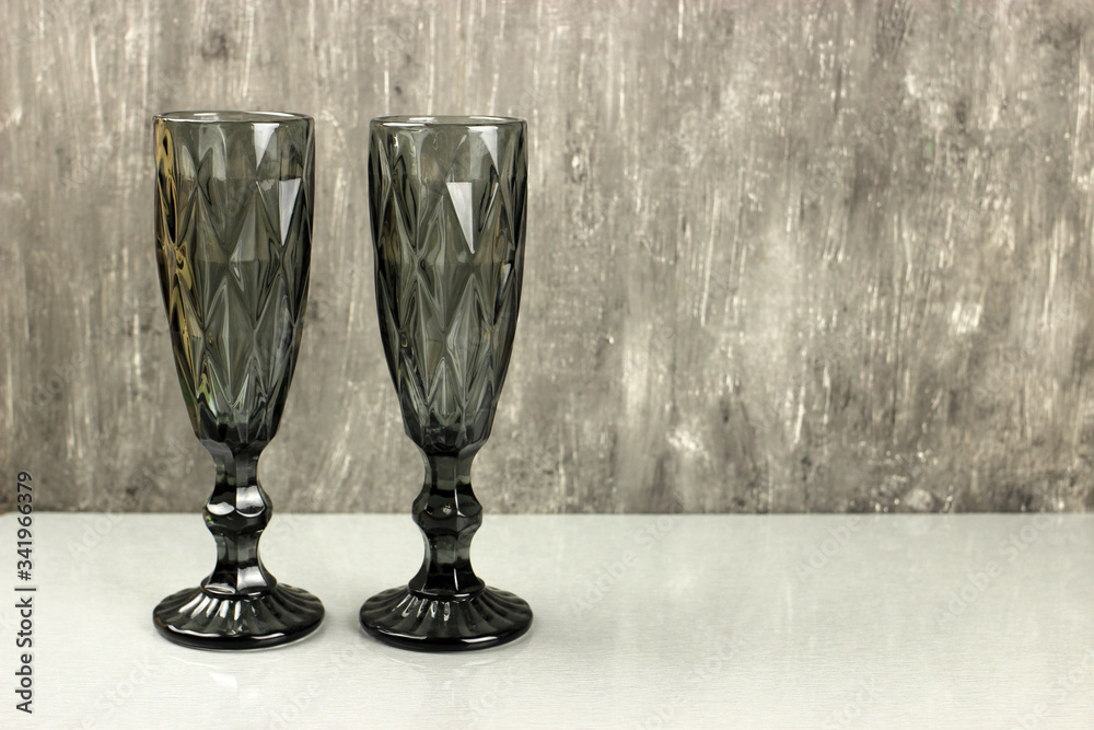 Two Dark champagne glasses on a grey background Two Dark champagne glasses on a grey background