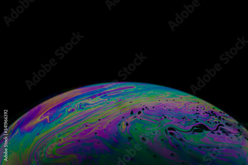 Soap bubble close up macro photography with colorful swirly pattern of light spectrum sphere shape