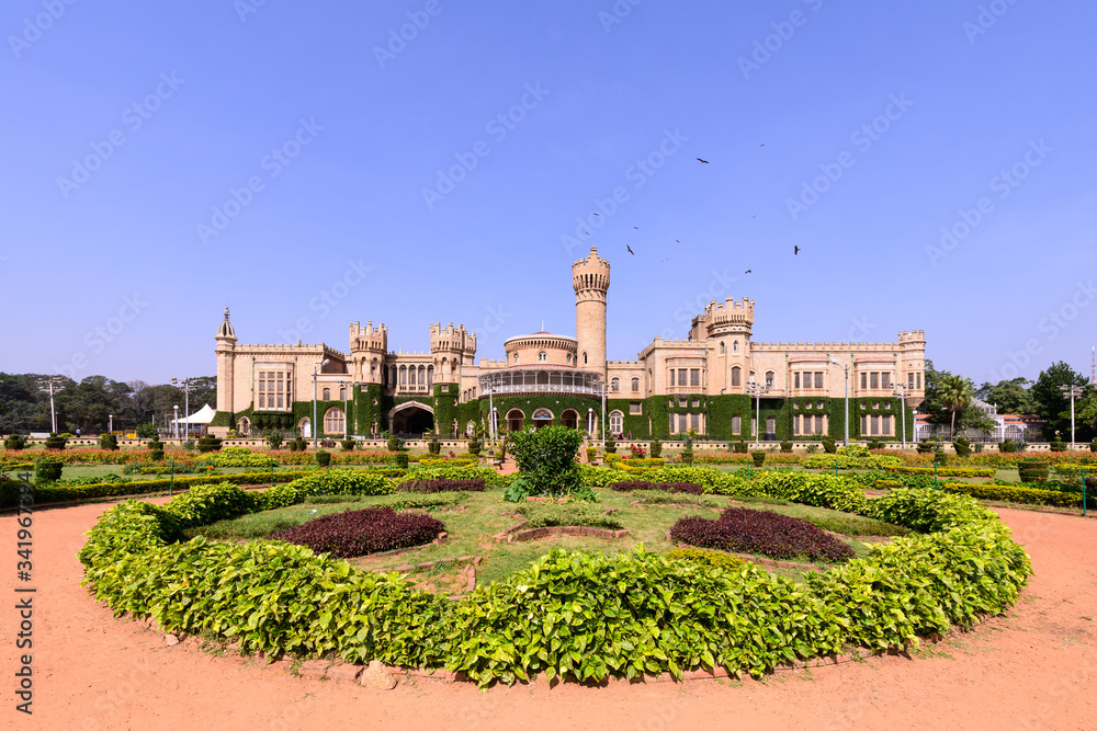 Beautiful exterior view of Bangalore Palace with a garden in front.